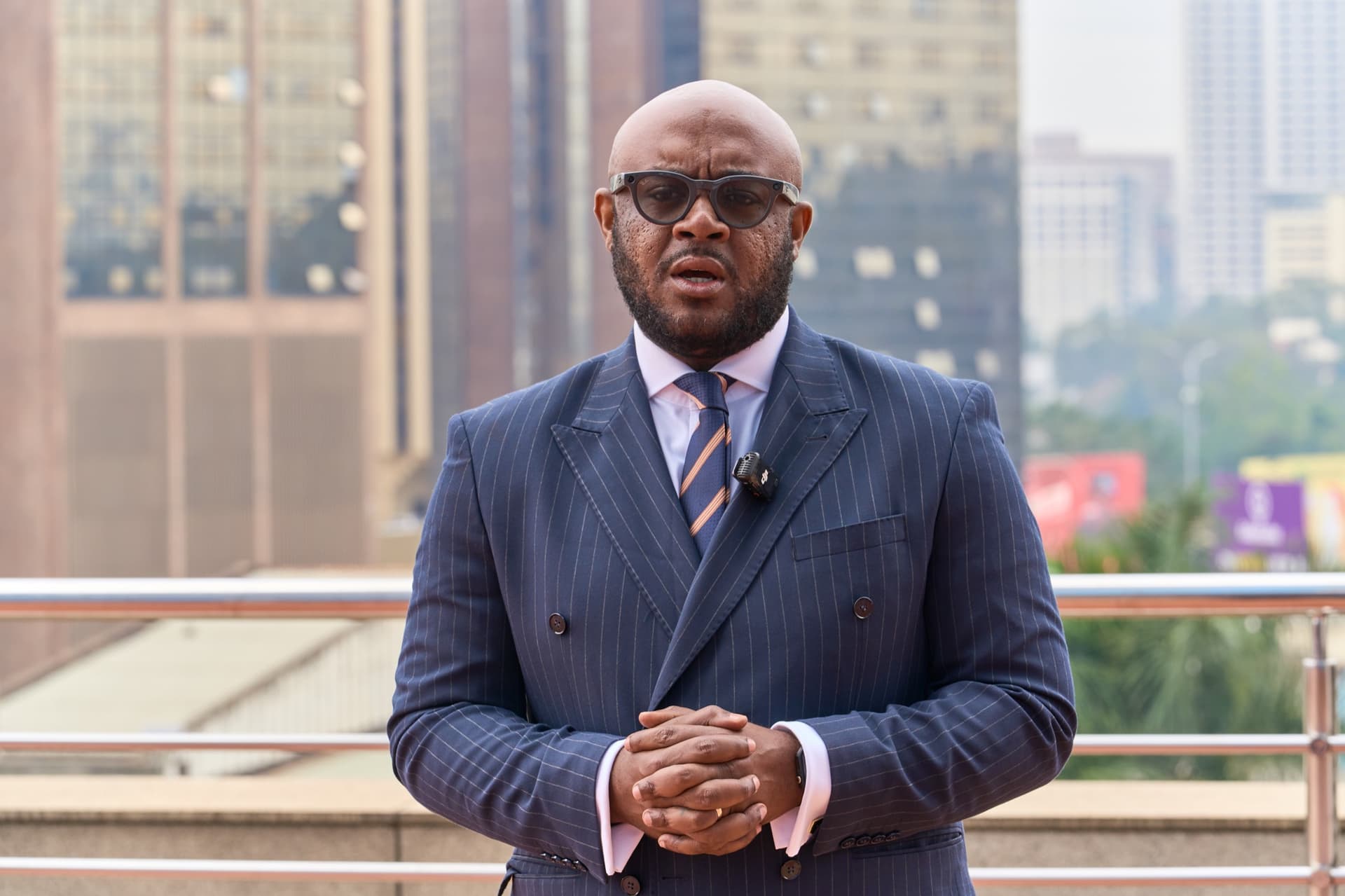 Lorenzo Daughtry-Chambers speaking, city skyline behind him